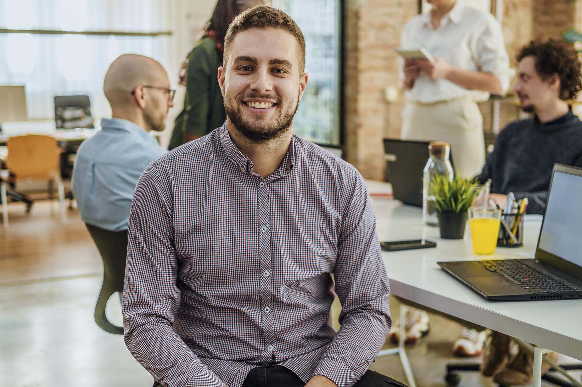 Photo of student smiling at camera in workplace setting